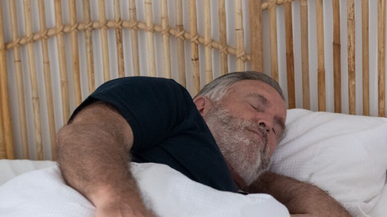 Male Patient Sleeping Soundly With SomnoMed Device