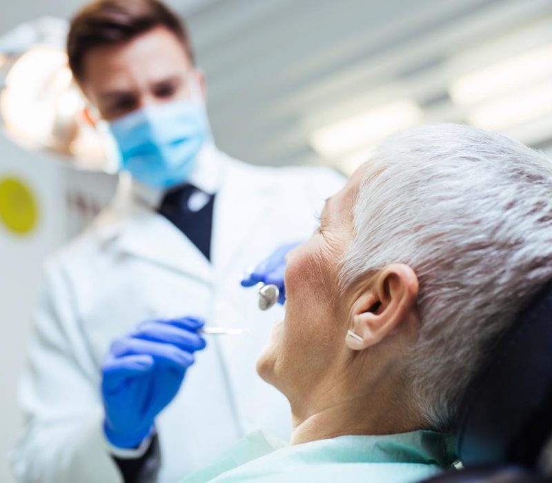 Frau besucht Zahnarzt zur Diagnose und Behandlung von Schnarchen.