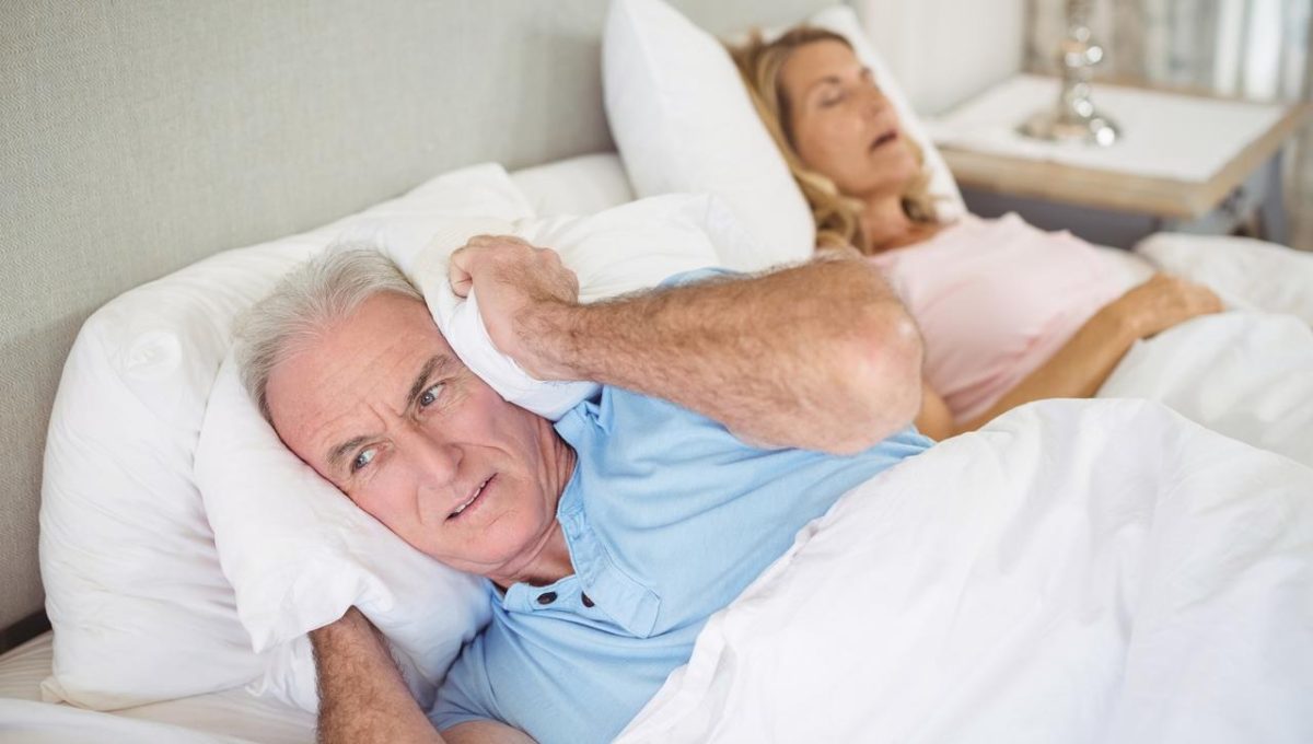 Husband Using Pillow To Cover Ears Due To Wife's Snoring